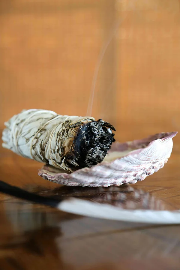Een smeulende bundel gedroogde salie op een schelp