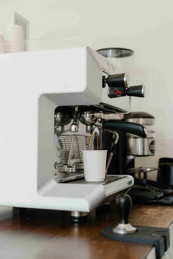 Een espressomachine met een wit bekertje eronder
