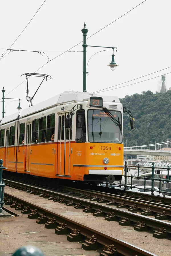 Een gele tram op de rails in een stad