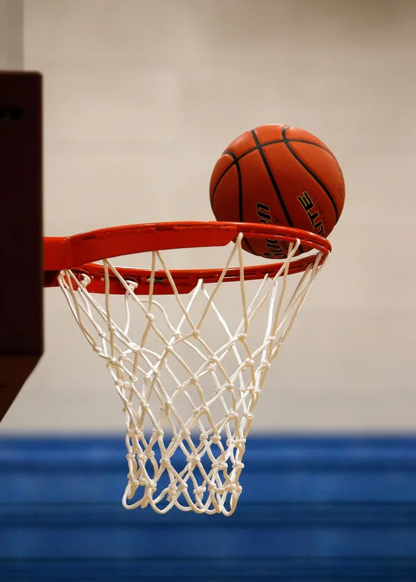 Een basketbal die in de ring valt